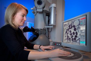 woman using electron microscope